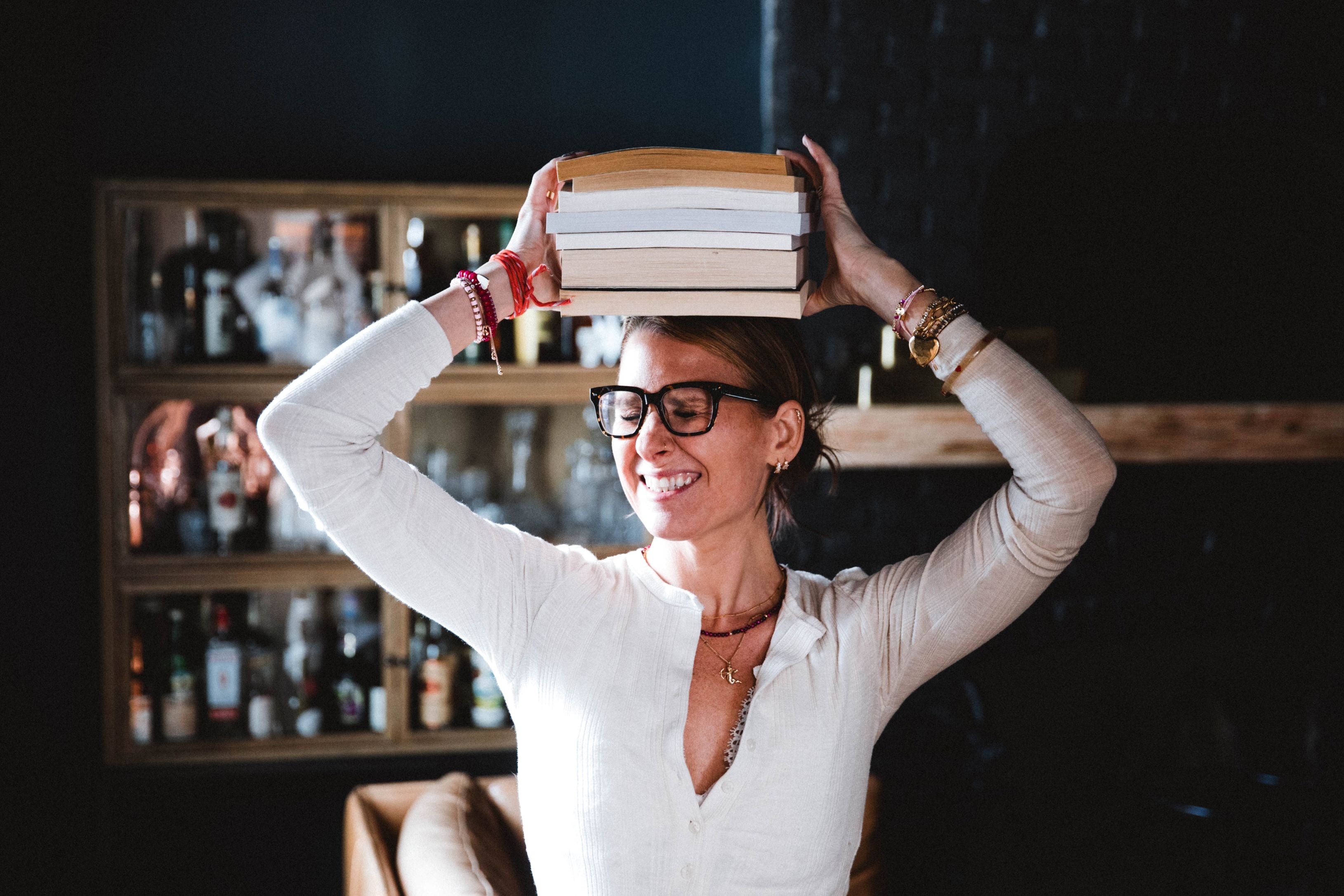 Tess holding a stack of books over her head. 